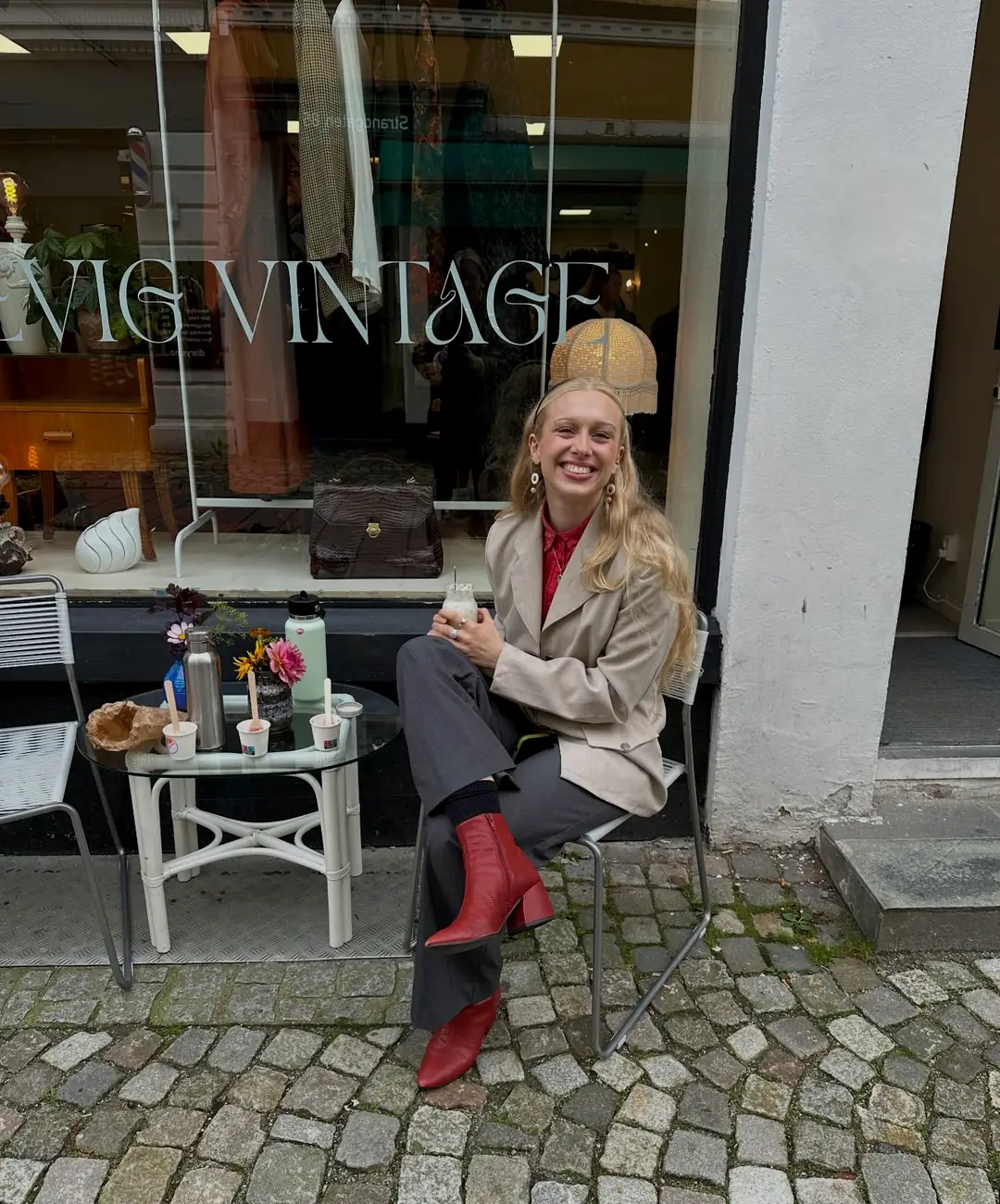 Butikkfasaden til Evig Vintage i Strandgaten 84, med navnet etset i vindusglasset og et bord på brosteinen utenfor.